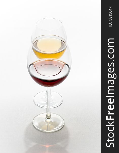 Two tall glasses isolated on white filled with red and white wine