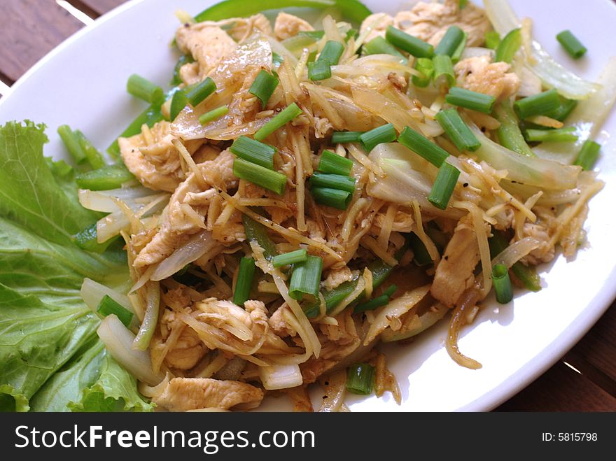 A summery meal of healthy chicken, stir-fried with ginger and served on a white plate. A summery meal of healthy chicken, stir-fried with ginger and served on a white plate.