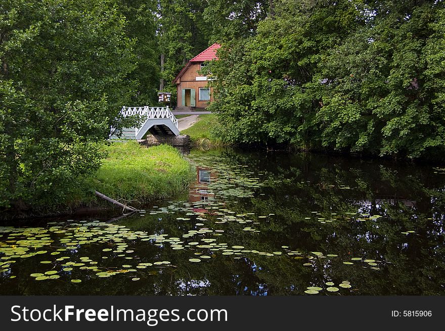 House with white bridge and river. House with white bridge and river.