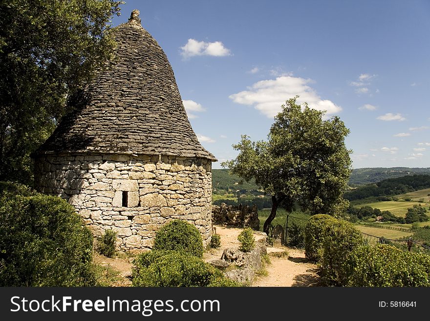 Small bell-shaped building with a round bricked roof, overlooking a French valley.