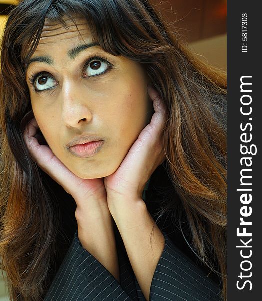 Young Islamic Businesswoman resting her head on her hands and looking upward. Young Islamic Businesswoman resting her head on her hands and looking upward.