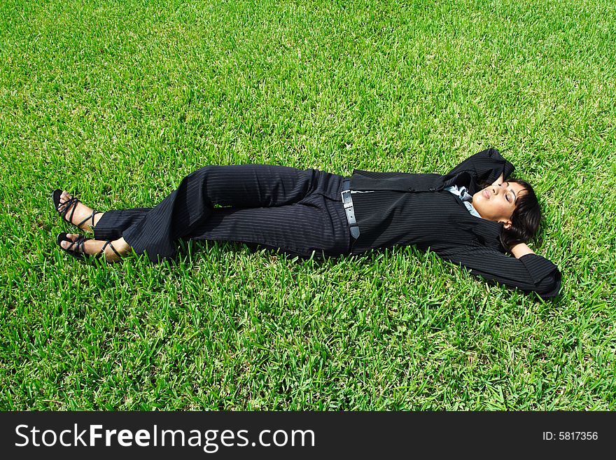 Young businesswoman relaxing on the grass. Young businesswoman relaxing on the grass