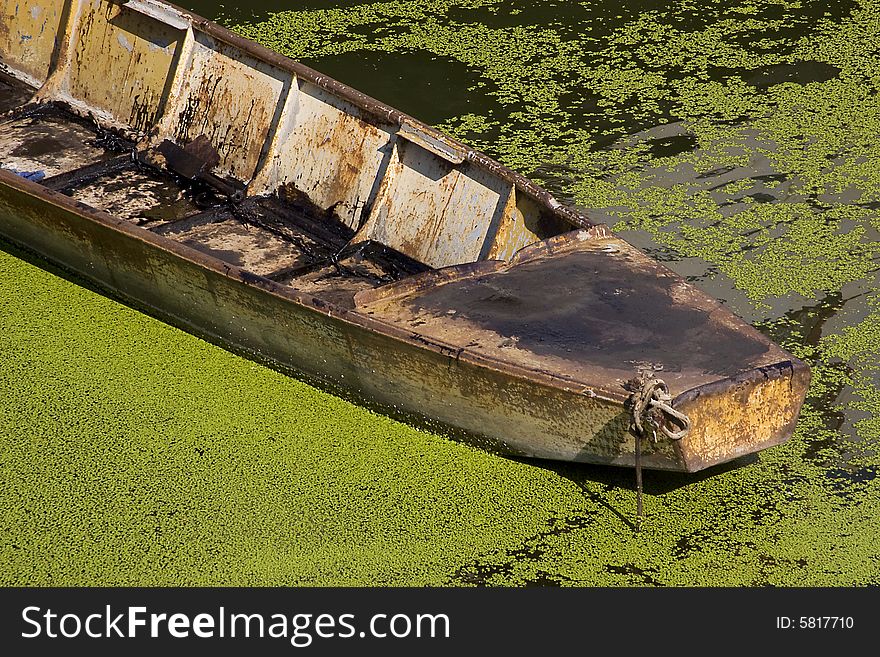 An old rusty  boat in green water. An old rusty  boat in green water