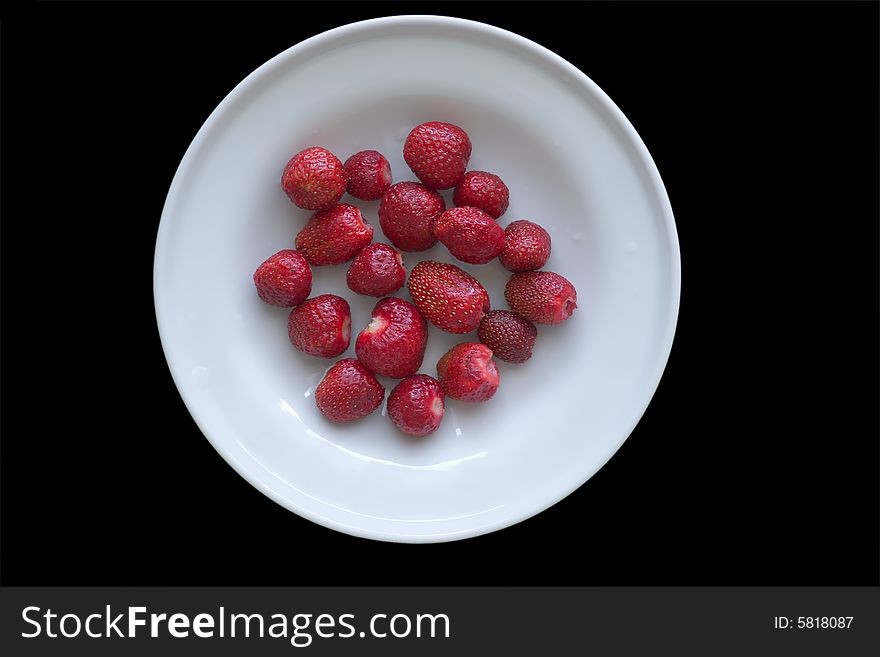 Plate with strawberries isolated on black