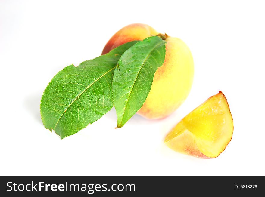 Ripe peach fruit with green leafs isolated on white