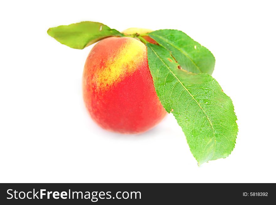 Ripe peach fruit with green leafs isolated on white