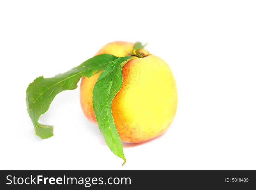 Ripe peach fruit with green leafs isolated on white