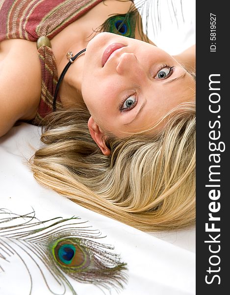 Portrait of beautiful girl with peacock a feather. Isolated over white background