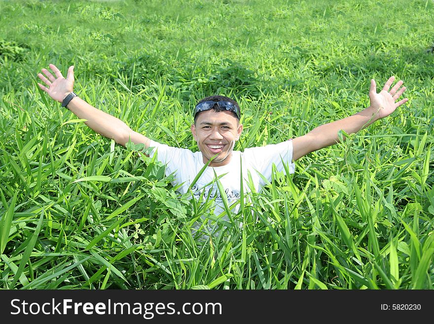 Man rise arm in the green grass. Man rise arm in the green grass