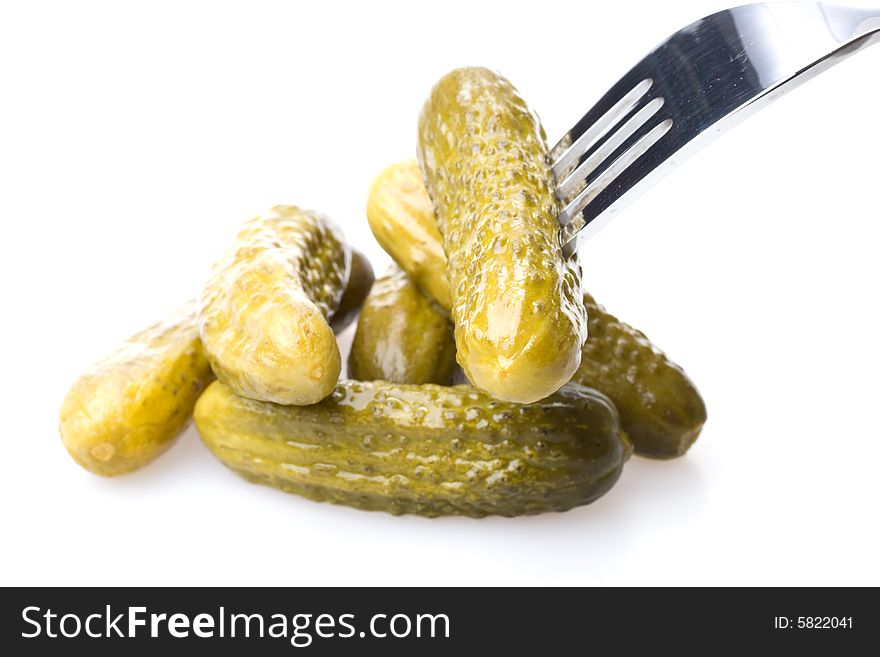 Crackling pickled gherkins on a plug on a white background