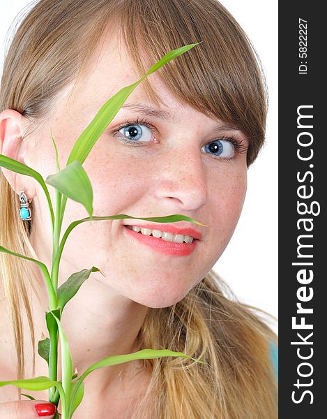 Portrait of the blue-eyed girl with green plant on white background