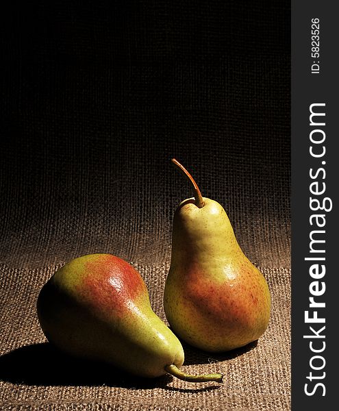 Two pears on burlap background