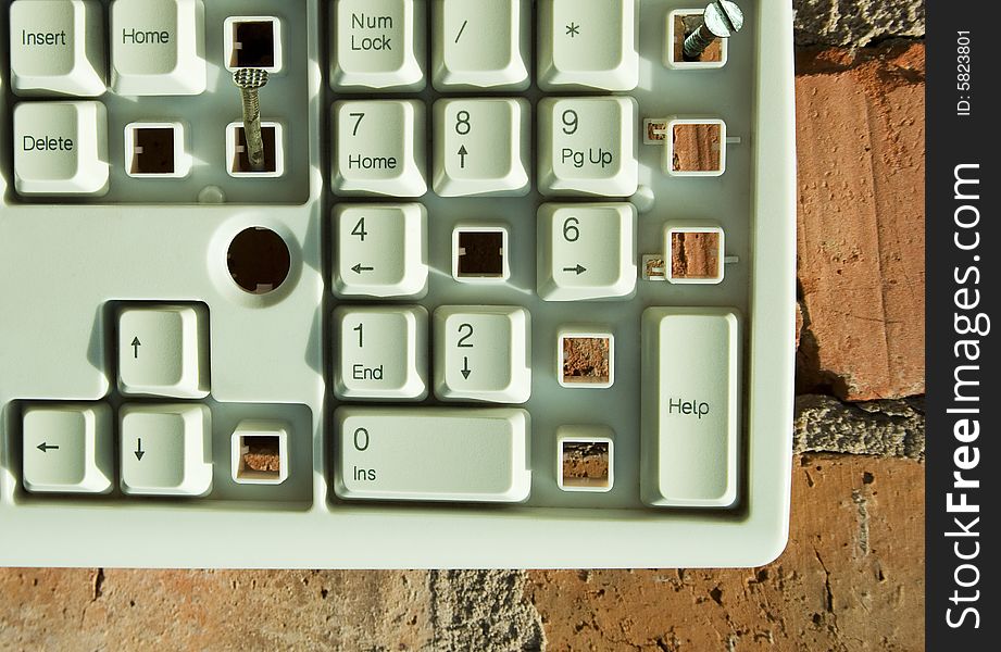 Disassembled keyboard with white button on the brick wall