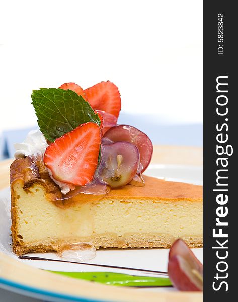A piece of cheesecake with strawberry and grape