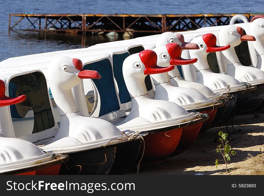 A list of goose figure boat on the lakeshore. A list of goose figure boat on the lakeshore.