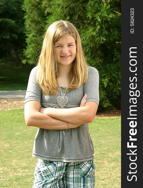 Teenage girl wearing a gray shirt laying in the grass