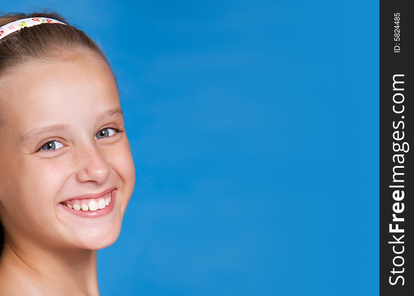 Close-up portrait of pretty young girl on blue background