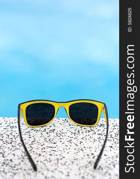 Black and yellow sunglasses with a blue background