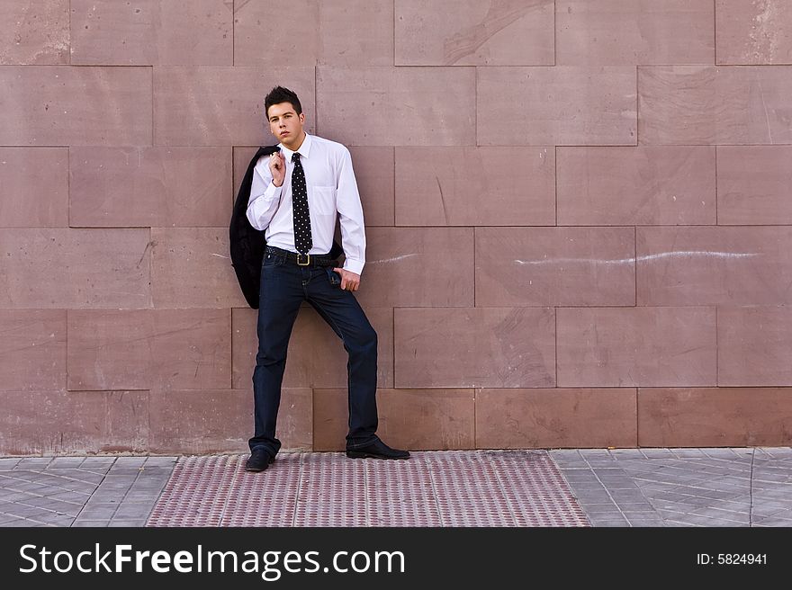 Young model as businessman posing on wall.