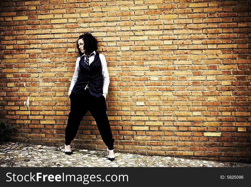 Young woman posing on a brickwall. Young woman posing on a brickwall.