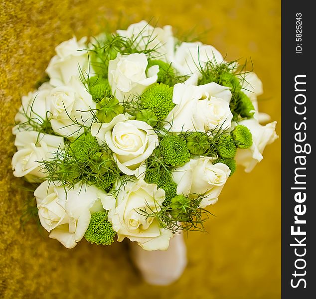 Wedding bouquet of white roses with lots of greenary lying on a carpet. Wedding bouquet of white roses with lots of greenary lying on a carpet.