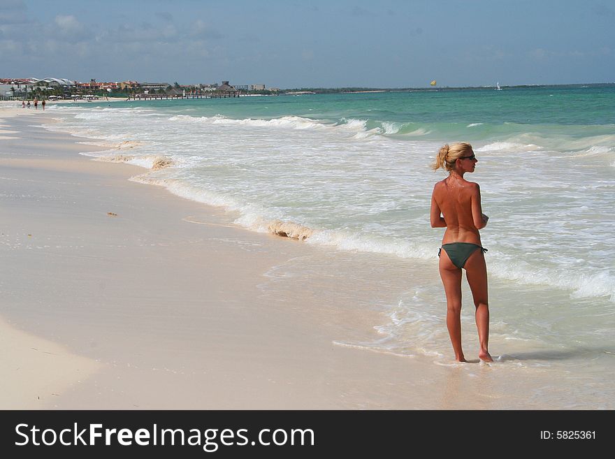 topless woman at beach showing her back and profile. topless woman at beach showing her back and profile