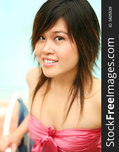 Beautiful young girl sit by pool side, showing happy expression. Beautiful young girl sit by pool side, showing happy expression