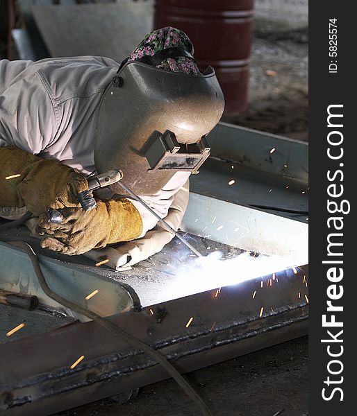 A welder working at shipyard during day shift
