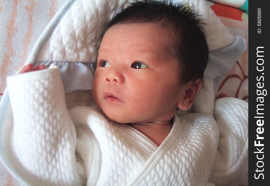 Lovely Infant in white on a bed