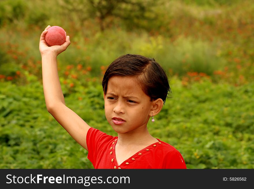 A small girl throwing the ball.