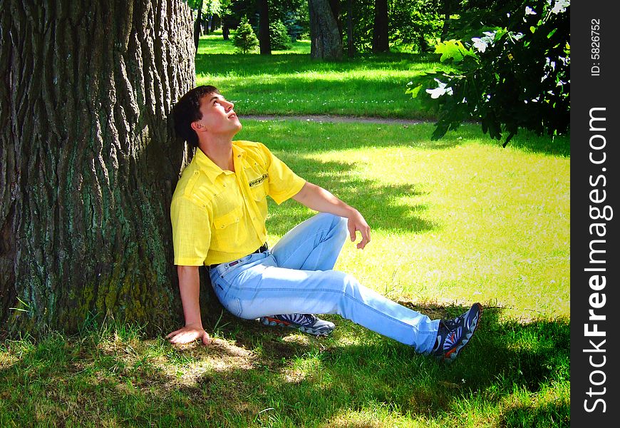 Photo of the young man under a big tree.