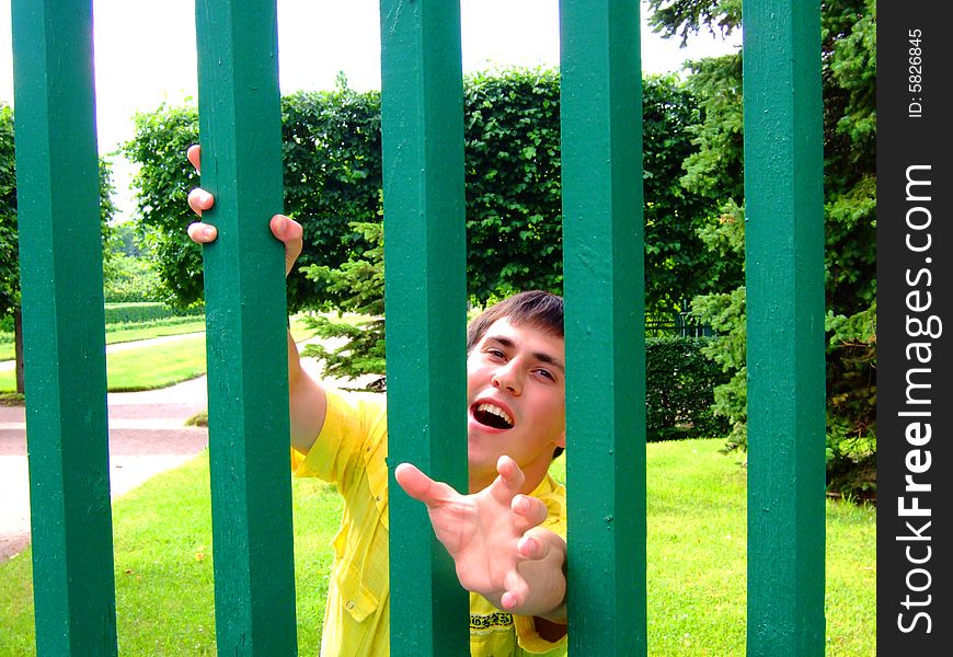 Photo of the young man behind a fence.