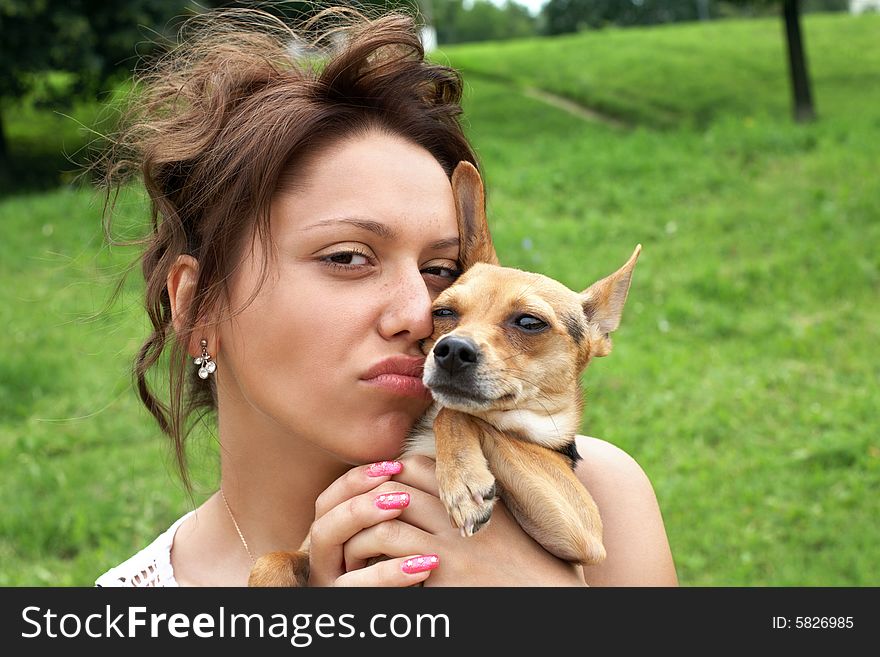 Girl with little dog (toy terrier) in the park. Girl with little dog (toy terrier) in the park
