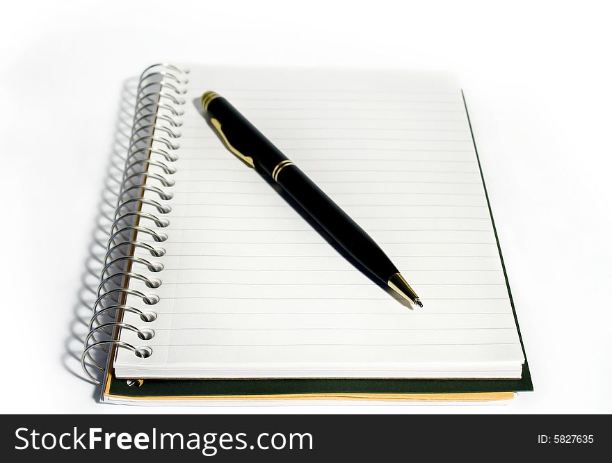 Spiral-bound notebook with ballpoint pen on white background. Spiral-bound notebook with ballpoint pen on white background
