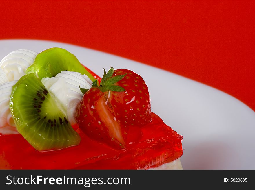 Fruit desert is on the plate, red jelly