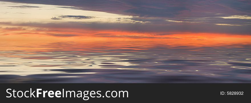 Sunset panorama and glitter water with grey clouds