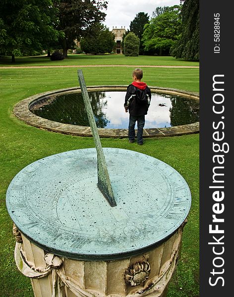 A boy stands beyond a classic sundial emphasising the fact that he will soon be grown up