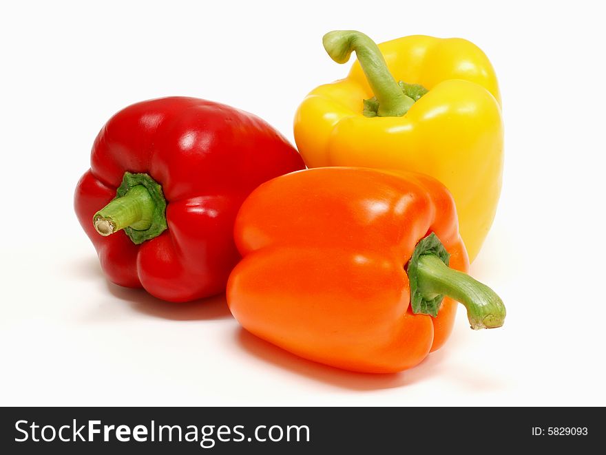 Red yellow and orange peppers on a white background