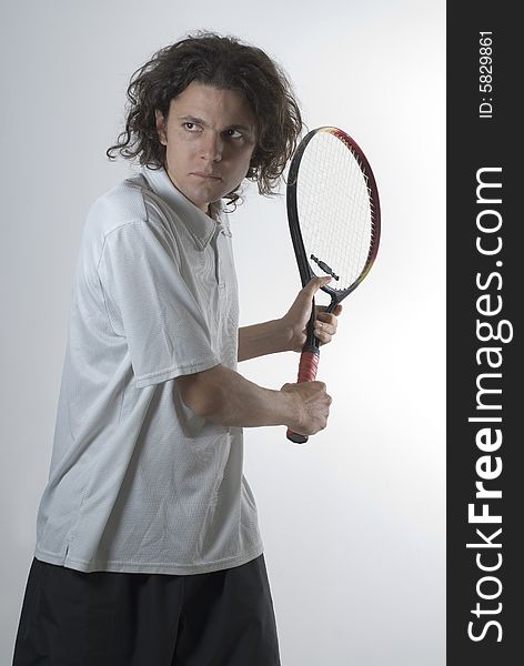 Tennis Player holding a racket preparing to hit a backhand - Vertically framed photograph. Tennis Player holding a racket preparing to hit a backhand - Vertically framed photograph