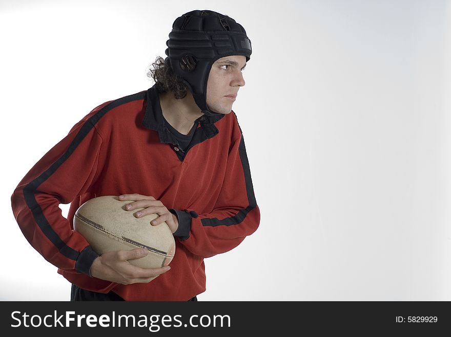 Rugby player holding a fooball with a serious look on his face. Horizontally framed photograph. Rugby player holding a fooball with a serious look on his face. Horizontally framed photograph