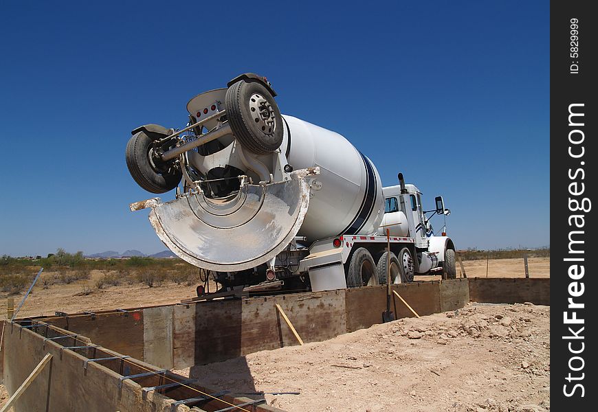 A cement mixing truck is parked in the desert. Horizontally framed shot. A cement mixing truck is parked in the desert. Horizontally framed shot.