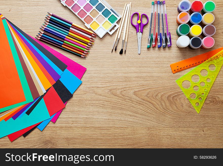 Set of school supplies with pencils, paint, pens, paper, scissors and rulers on the floor