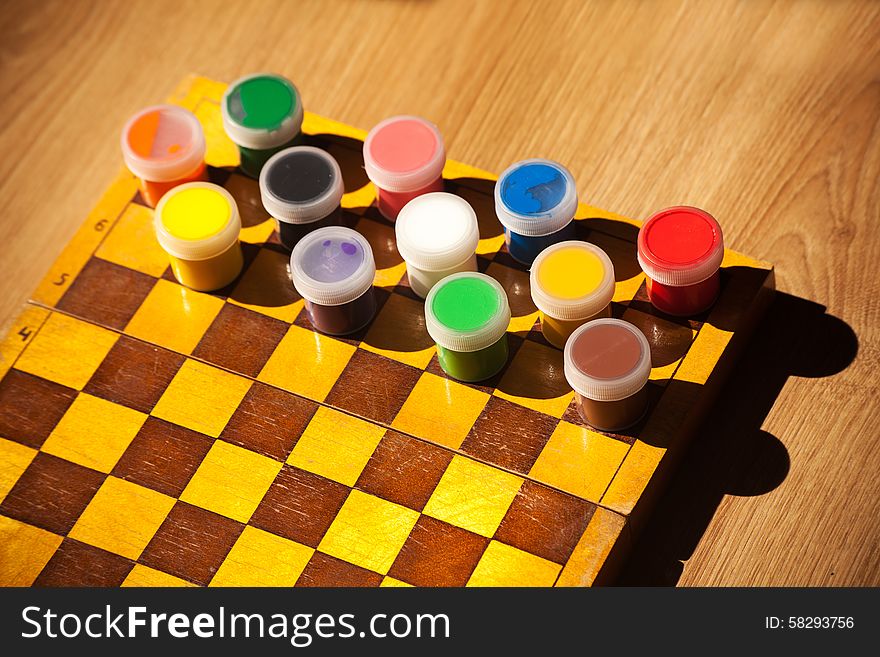 Colourful watercolor paint on the chessboard closeup