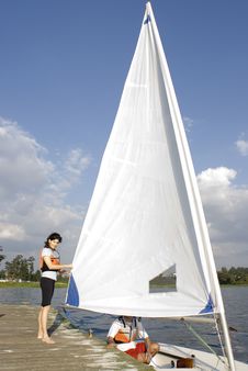 Man And Woman Next To Sailboat On Water - Vertical Royalty Free Stock Photo