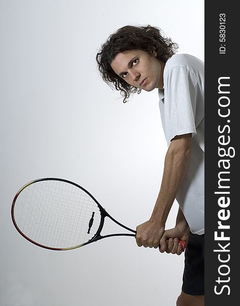 Man standing holding a tennis racket with a serious look on his face. Vertically framed photograph. Man standing holding a tennis racket with a serious look on his face. Vertically framed photograph