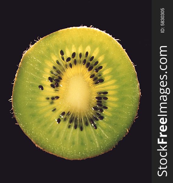 Photo of a sliced kiwi fruit exposing its seeds.