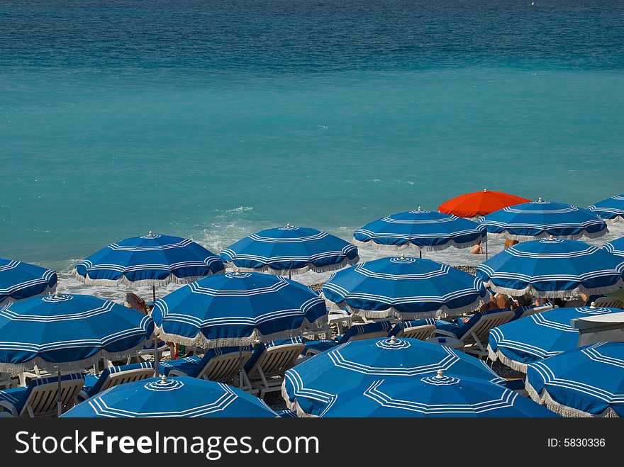 Red sunshade surrounded by blue ones