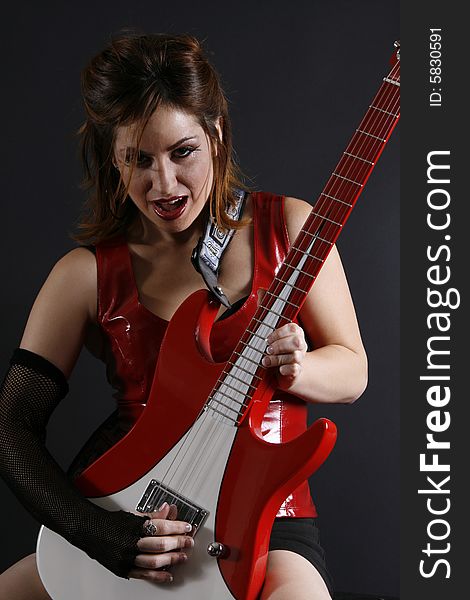 Urban girl in red with electric guitar. Urban girl in red with electric guitar