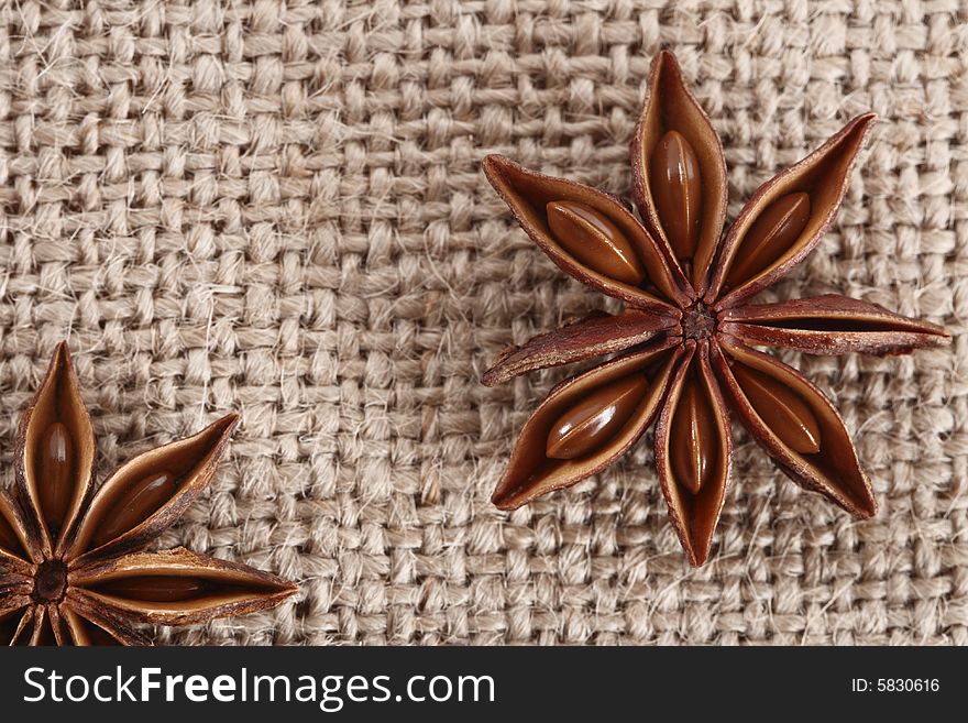 Anis star on burlap canvas background, close-up