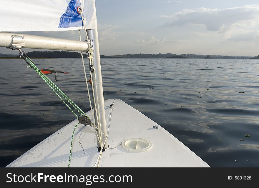 View of a lake from the bow of the sailboat.  Horizontally framed shot. View of a lake from the bow of the sailboat.  Horizontally framed shot.